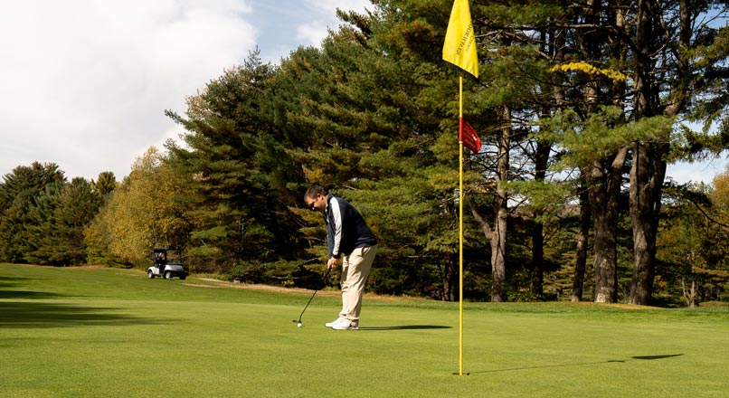 Golfer putting on green
