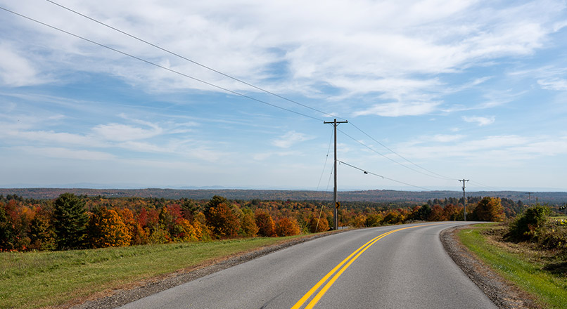 Rural road with view of trees & landscape